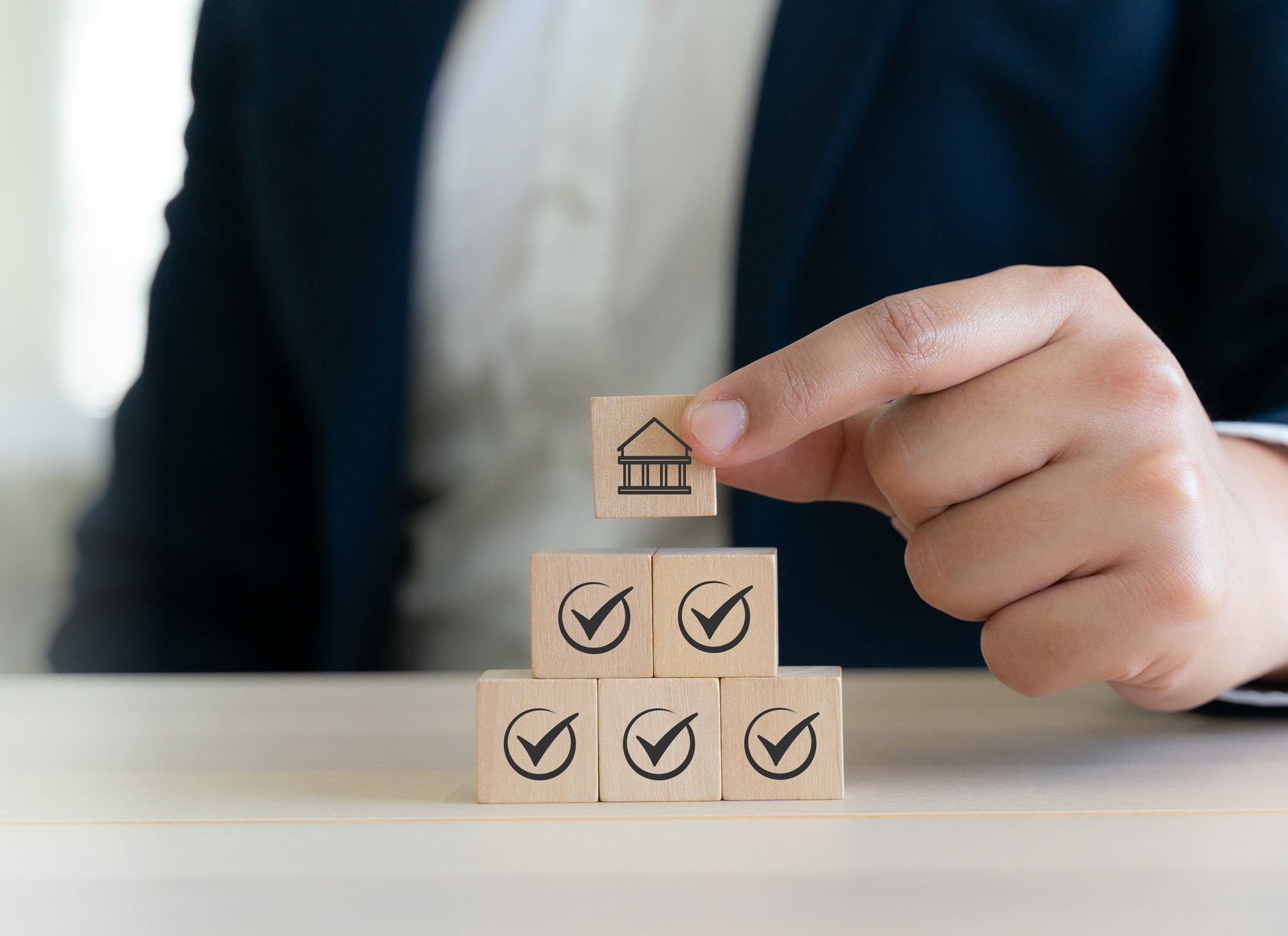 Holzklötze mit Häkchen, die für die Einhaltung von Unternehmensrichtlinien und -vorschriften sowie für ethisches Unternehmensverhalten stehen.