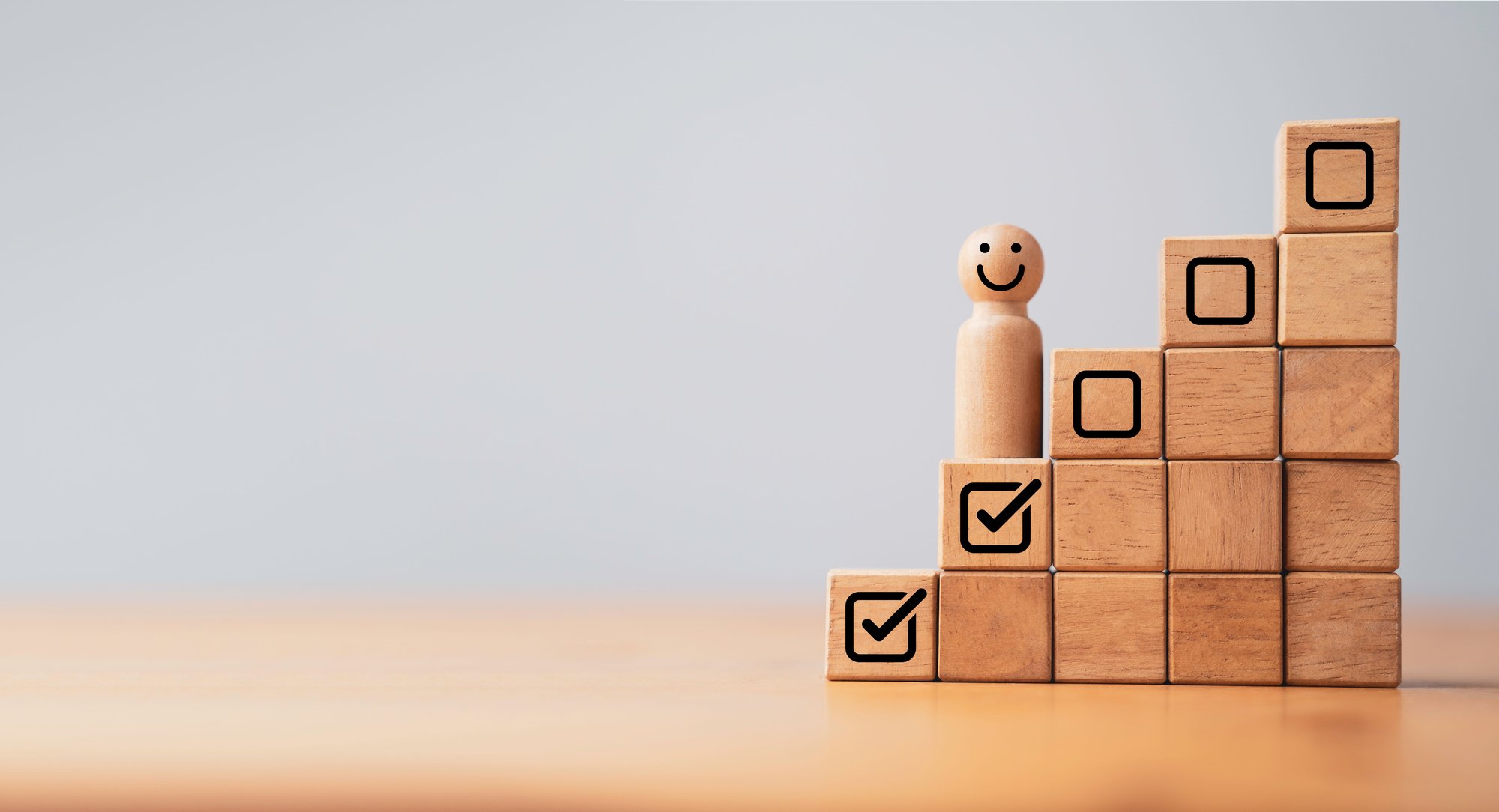 Holzfigur auf Holzklötzchentreppe stehend